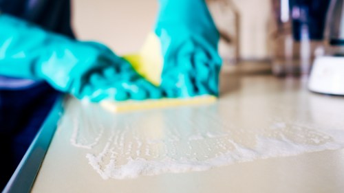 Technician using safe carpet cleaning practices with protective equipment